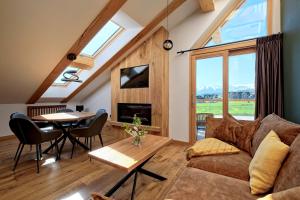 a living room with a couch and a table at Białka Residence Ski - 50 m do Termy Bania, Odkryj-Białke in Białka Tatrzańska