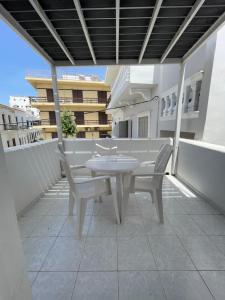 a white table and chairs on a balcony at Manto Apartments in Tinos