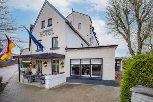 ein Hotel mit Tischen und Stühlen außerhalb in der Unterkunft Fletcher Hotel Restaurant De Geulvallei in Valkenburg