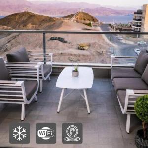 einen Balkon mit Sofas, einem Tisch und Aussicht in der Unterkunft Sea View Boutique Apartment in Eilat