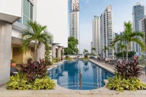 a swimming pool with palm trees and buildings at Marriott Executive Apartments Panama City, Finisterre in Panama City