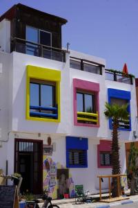 a building with colorful windows and a palm tree in front at GUEST HOUSE in Imsouane