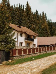 una casa su una collina con una recinzione e alberi di MountHoff Retreat a Moroeni