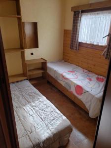 two beds in a small room with a window at Chalet 176 in Durbuy