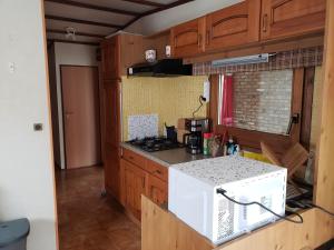 a kitchen with a stove and a white microwave at Chalet 176 in Durbuy