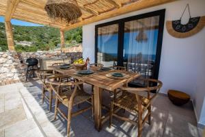 een eetkamer met een houten tafel en stoelen bij Eunoia Porto Katsiki in Áyios Nikólaos Nirás