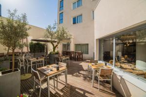 a patio with tables and chairs and a building at Courtyard by Marriott Paris Arcueil in Arcueil