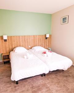 two beds in a room with white sheets and towels at VVF Plaine d'Alsace Obernai Strasbourg in Obernai