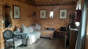 a living room with a couch and a chair at Casa Tumi Cottages in Maseru