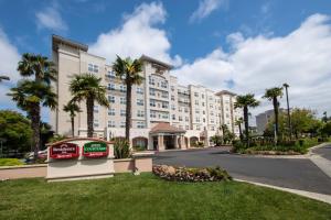 a large hotel with palm trees and a street at Residence Inn by Marriott Newark Silicon Valley in Newark