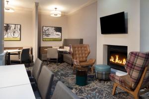 紐華克的住宿－Residence Inn by Marriott Newark Silicon Valley，酒店客房设有壁炉、桌子和椅子。