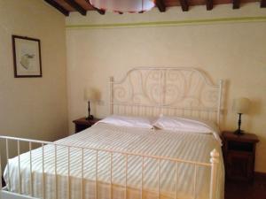 a bedroom with a white bed with two nightstands and two lamps at Tenuta Casabianca in Murlo +46 photos