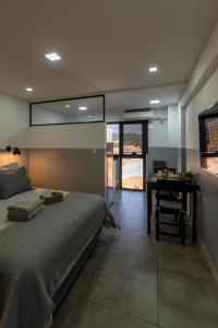 a bedroom with a bed and a table and a desk at Departamento céntrico con estacionamiento gratis in San Salvador de Jujuy