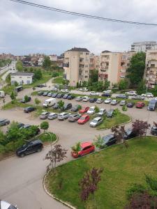 ein Parkplatz mit Autos in einer Stadt geparkt in der Unterkunft H Apartament in Pristina