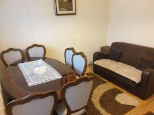 ein Wohnzimmer mit einem Tisch und einem Sofa in der Unterkunft H Apartament in Pristina