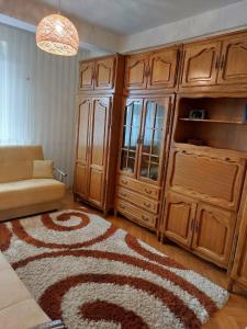 ein Wohnzimmer mit einem großen Schrank und einem Teppich in der Unterkunft H Apartament in Pristina