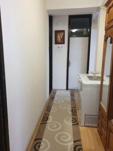 einen Flur mit einem Bad mit einem Waschbecken und einem Spiegel in der Unterkunft H Apartament in Pristina
