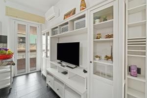 een woonkamer met witte planken en een flatscreen-tv bij Nonna Gina in Arbus