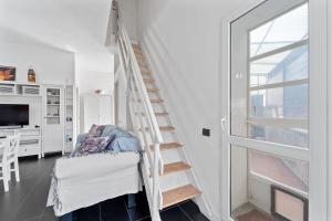 een witte trap in een kamer met een bed en een raam bij Nonna Gina in Arbus