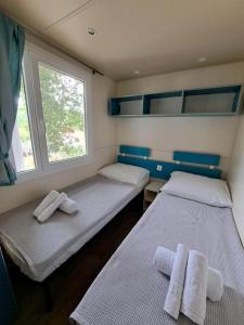 Duas camas num pequeno quarto com uma janela em Borić Mobile Homes in Bijela Uvala and Zelena Laguna em Porec