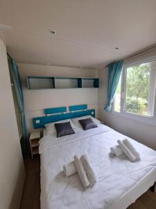 um quarto com uma grande cama branca e 2 almofadas em Borić Mobile Homes in Bijela Uvala and Zelena Laguna em Porec