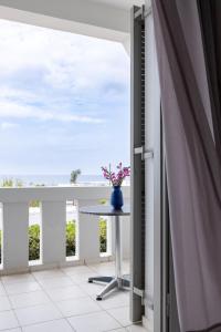 - Balcón con mesa y ventana en Keti Apartments, en Adelianos Kampos