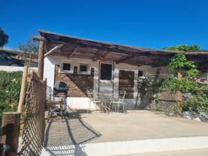 LameirosStudio GECKO Pego Longo的房屋前设有带桌椅的天井。