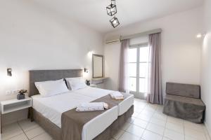 Habitación de hotel con cama y silla en Keti Apartments, en Adelianos Kampos