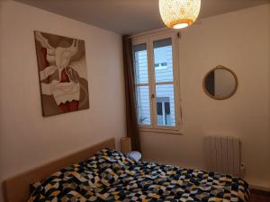 een slaapkamer met een bed en een schilderij aan de muur bij Appartement Saintes, centre historique in Saintes