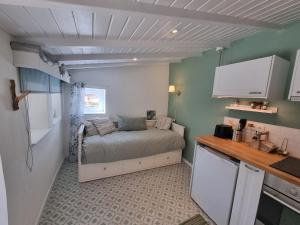 a small kitchen with a bed in a small room at Studio GECKO Pego Longo in Lameiros