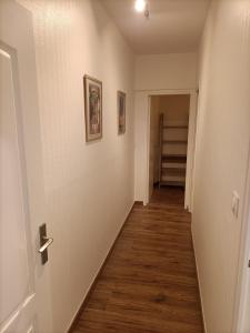 a hallway with white walls and a wooden floor at Appartement Saintes, centre historique in Saintes