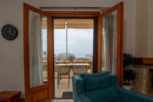 Una sala de estar con un sofá azul y un reloj. en Contemporary 2 bedroom apt 5 min walk from Kissamos center, en Kissamos