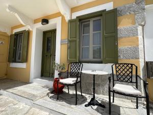 a patio with two chairs and a table in front of a building at Thea in Symi