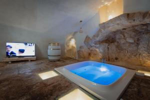 a bathroom with a bath tub and a tv at Arquati Suite Luxury Apartment in Ostuni