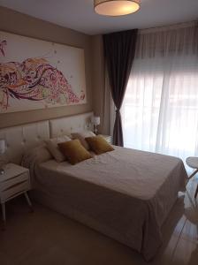 ein Schlafzimmer mit einem Bett und einem Wandgemälde in der Unterkunft Apartamento edificio Miramar in Oropesa del Mar