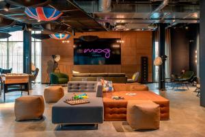 a living room with a couch and a table at Moxy London Heathrow Airport in Hounslow