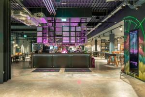 a large room with a bar and a restaurant at Moxy London Heathrow Airport in Hounslow