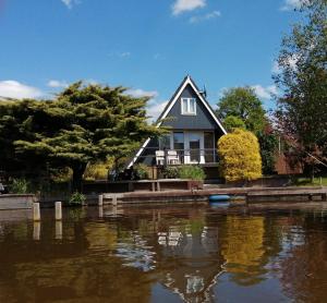a house next to a river with a house at Ferienhaus Brungers in Südbrookmerland