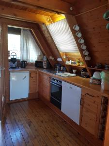 a kitchen with white appliances and wooden floors at Ferienhaus Brungers in Südbrookmerland