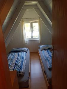 two beds in a small room with a window at Ferienhaus Brungers in Südbrookmerland