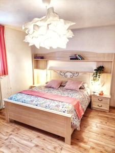 ein Schlafzimmer mit einem großen Bett und einem Kronleuchter in der Unterkunft Casa Pepolina, zona tranquilla, piano terra con parcheggio in Malesco