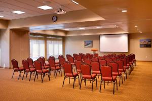 a conference room with red chairs and a screen at TownePlace Suites by Marriott Vernal in Vernal
