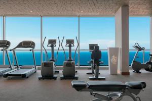 a gym with cardio equipment in front of a large window at Four Points by Sheraton Oran in Oran