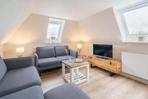 a living room with a couch and a tv at Ferienanlage am Trift in Westerland