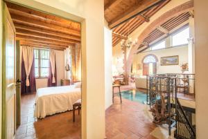 a bedroom with a bed and a living room at Villa Il Fornacino in Rapolano Terme