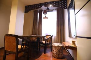 a dining room with a table and chairs and a window at Hotel Grand Kailash,Kotdwara in Kotdwāra