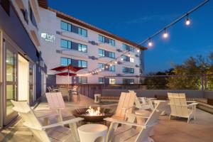 a patio with chairs and a fire pit in front of a building at Aloft Scottsdale in Scottsdale