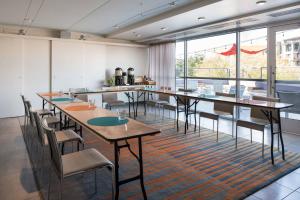 a room with tables and chairs and a large window at Aloft Scottsdale in Scottsdale