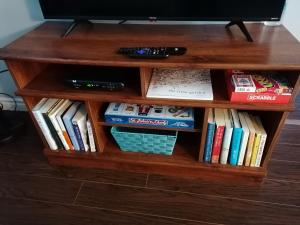 a book shelf filled with books and a tv at Two Bedroom Apartment Near St John's Airport in St. John's