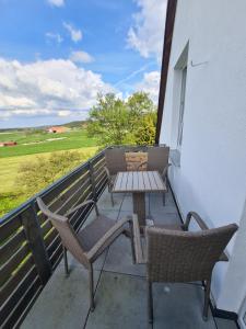a patio with two chairs and a table on a balcony at Pilgrims "Rosalie" große Fewo mit 3 Schlafzimmern, 1Bad, 2 WC, Balkon, fast Internet in Brilon